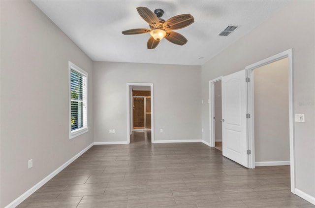 unfurnished room with a ceiling fan, baseboards, and visible vents
