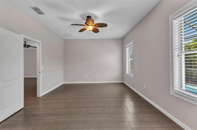 unfurnished room with baseboards, visible vents, wood finished floors, and ceiling fan