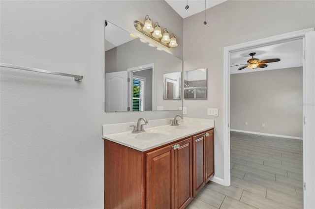full bathroom with a ceiling fan, a sink, double vanity, and baseboards