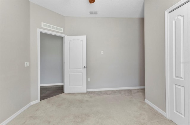 spare room featuring baseboards, carpet flooring, and visible vents