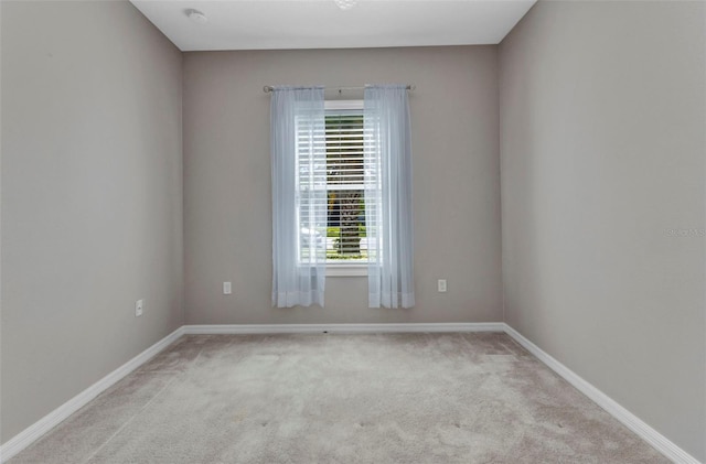 empty room featuring baseboards and carpet flooring