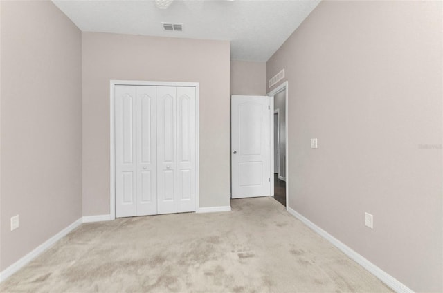 unfurnished bedroom featuring a closet, baseboards, visible vents, and carpet