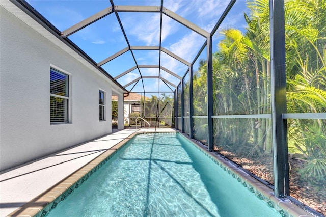 pool featuring glass enclosure and a patio
