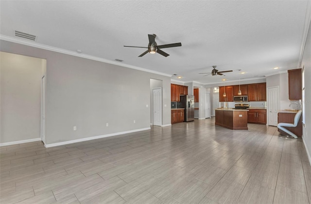 unfurnished living room with visible vents, crown molding, baseboards, and ceiling fan