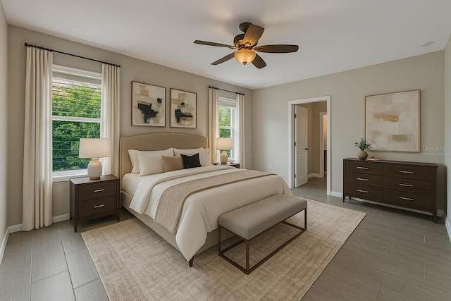 bedroom with a ceiling fan, baseboards, and light wood-type flooring