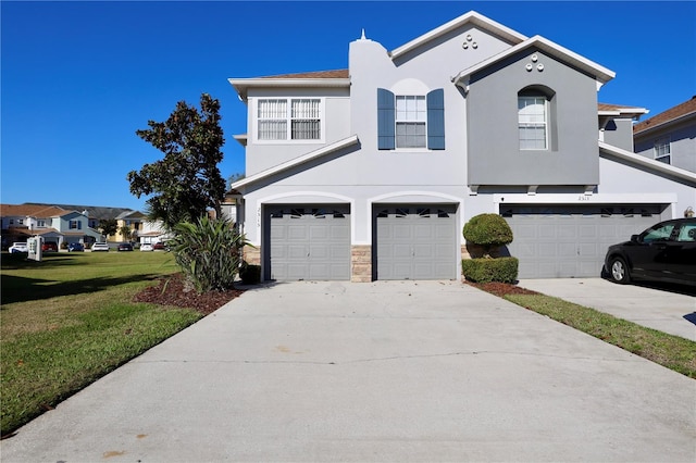 view of front facade featuring a front lawn, concrete driveway, a garage, and stucco siding