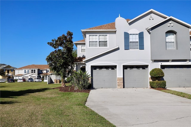 view of front of home featuring stucco siding, an attached garage, driveway, and a front lawn