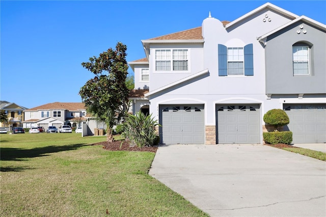 view of front of property featuring stucco siding, driveway, an attached garage, and a front lawn