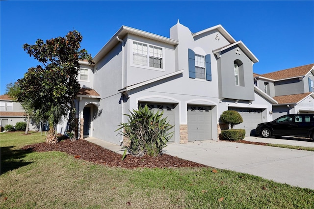 view of front facade featuring stucco siding, an attached garage, driveway, and a front yard