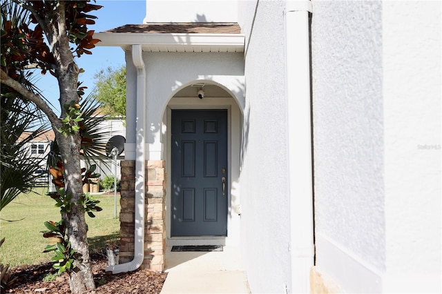 entrance to property featuring stucco siding