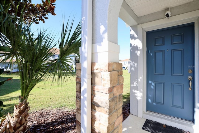 entrance to property featuring a yard