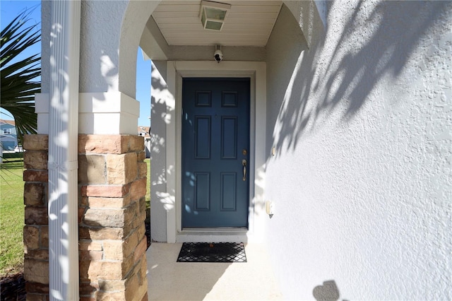 doorway to property featuring stucco siding