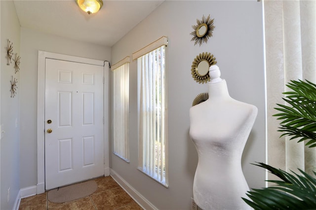 foyer entrance featuring tile patterned floors and baseboards