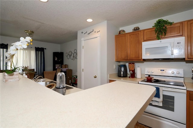 kitchen featuring brown cabinetry, white appliances, a textured ceiling, and light countertops