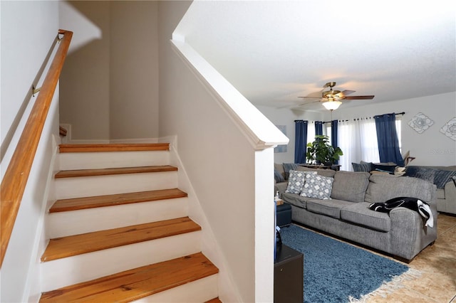 staircase featuring a ceiling fan