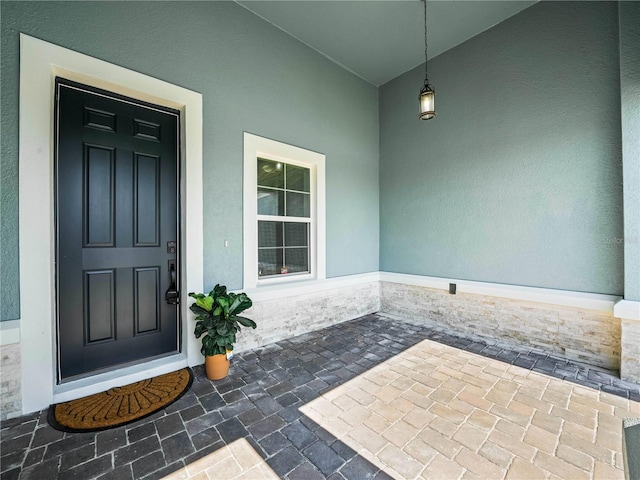 doorway to property featuring stucco siding