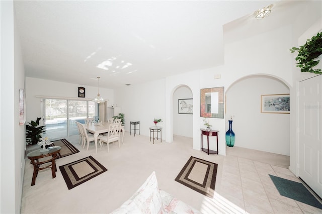 rec room featuring arched walkways, a chandelier, and tile patterned flooring