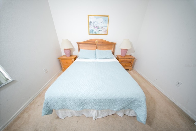 bedroom featuring baseboards and light colored carpet