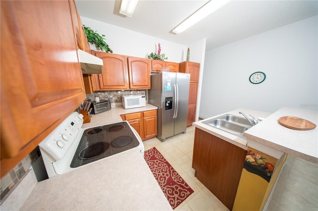 kitchen with white appliances, a sink, decorative backsplash, light countertops, and under cabinet range hood