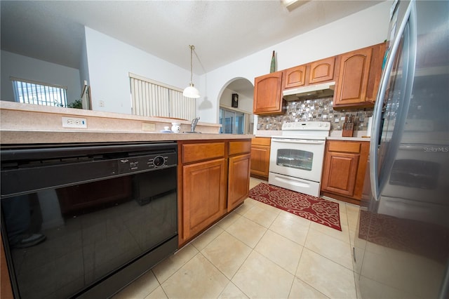 kitchen with under cabinet range hood, light countertops, black dishwasher, freestanding refrigerator, and electric range