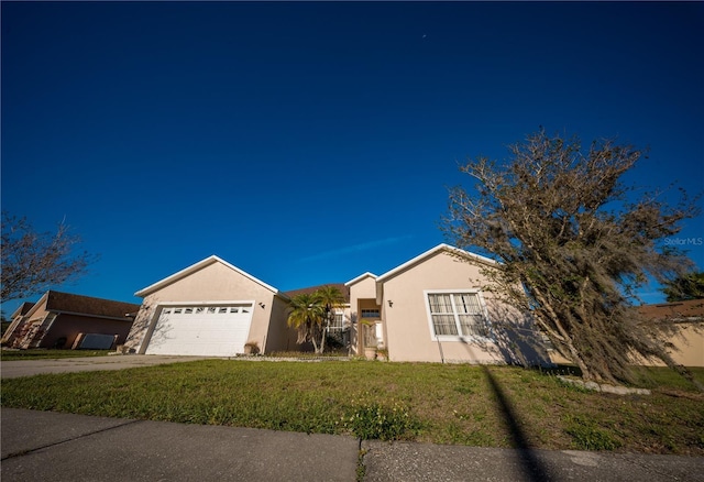 view of front of house with stucco siding, an attached garage, concrete driveway, and a front yard