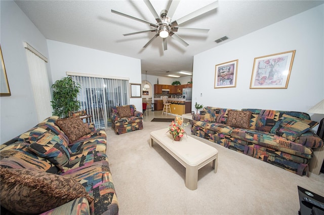 living room with light carpet, visible vents, and ceiling fan