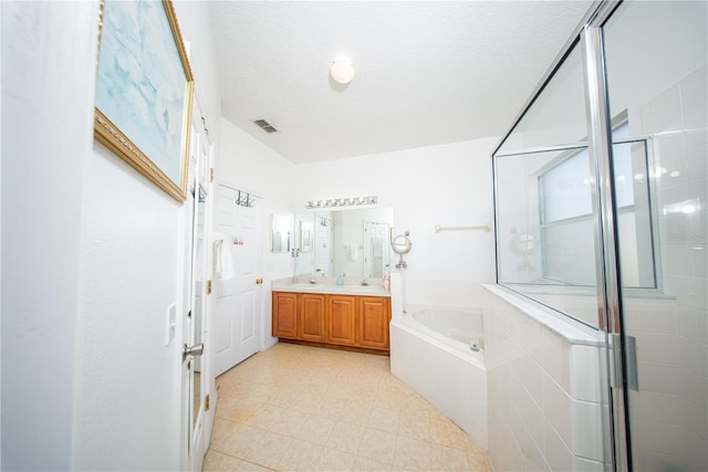 bathroom featuring visible vents, double vanity, a stall shower, a sink, and a garden tub