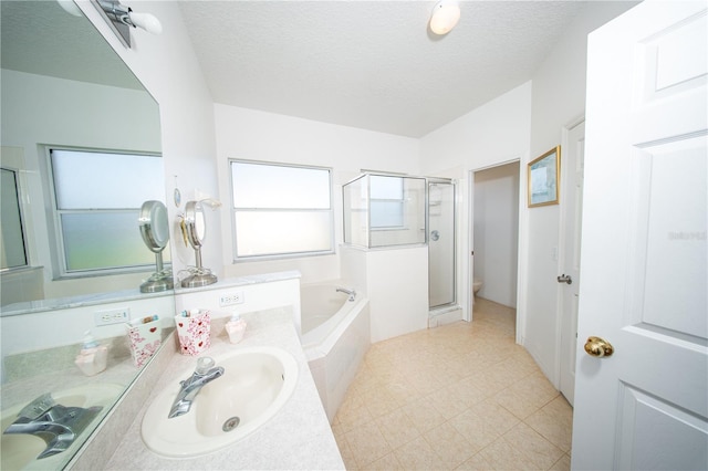 bathroom with vanity, a garden tub, a stall shower, and a textured ceiling