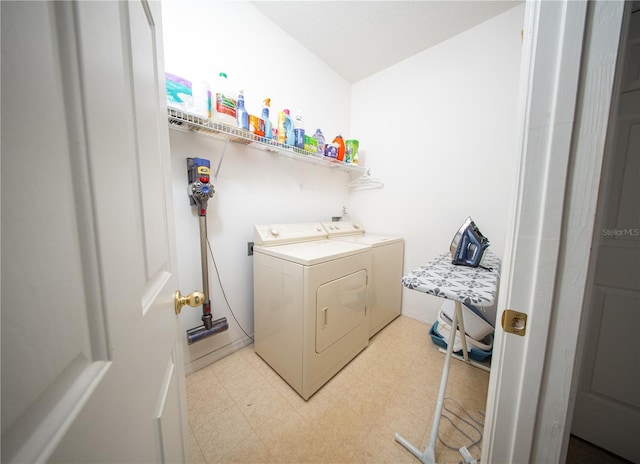 clothes washing area featuring light floors, independent washer and dryer, and laundry area