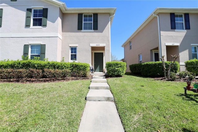 view of front of home featuring stucco siding and a front lawn