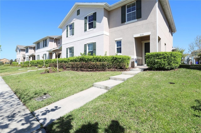 multi unit property featuring a residential view, stucco siding, and a front lawn