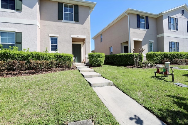 view of front of property featuring stucco siding and a front yard