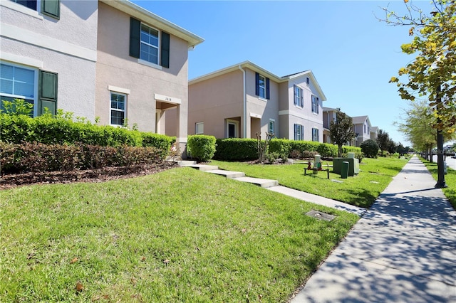 exterior space with stucco siding, a residential view, and a yard