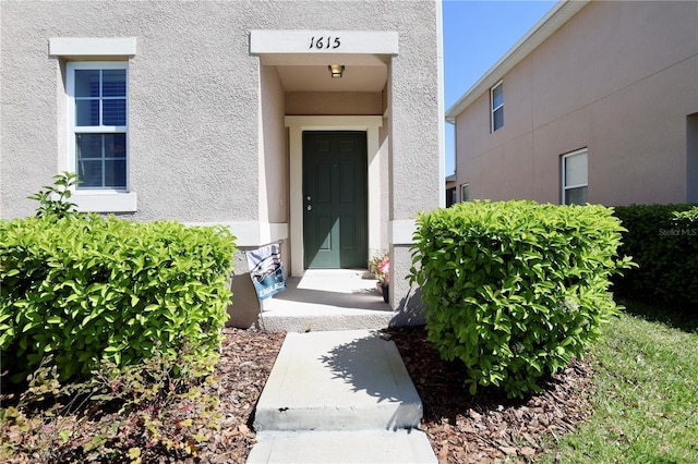 entrance to property with stucco siding