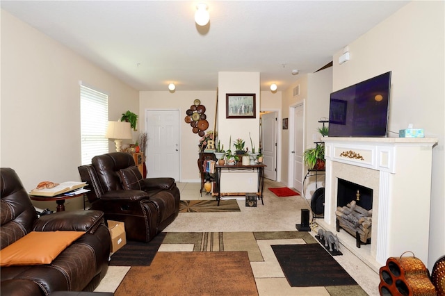 carpeted living area with a fireplace with flush hearth and visible vents