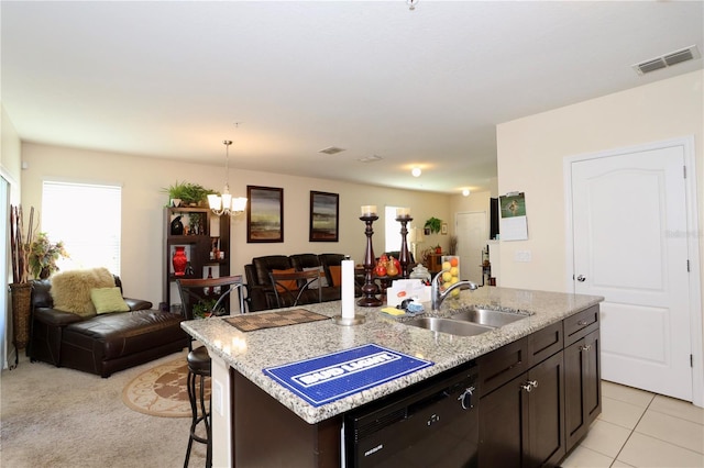 kitchen with a breakfast bar area, visible vents, a sink, black dishwasher, and open floor plan