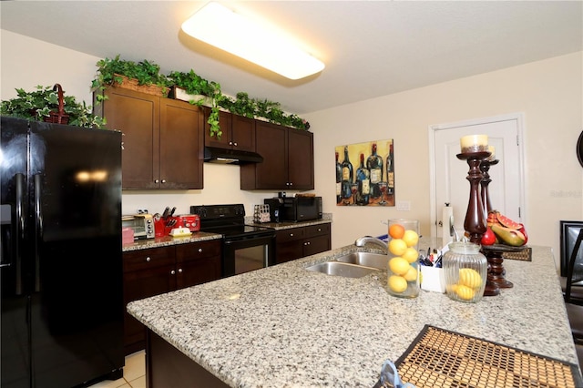 kitchen with black appliances, a kitchen breakfast bar, under cabinet range hood, and a sink