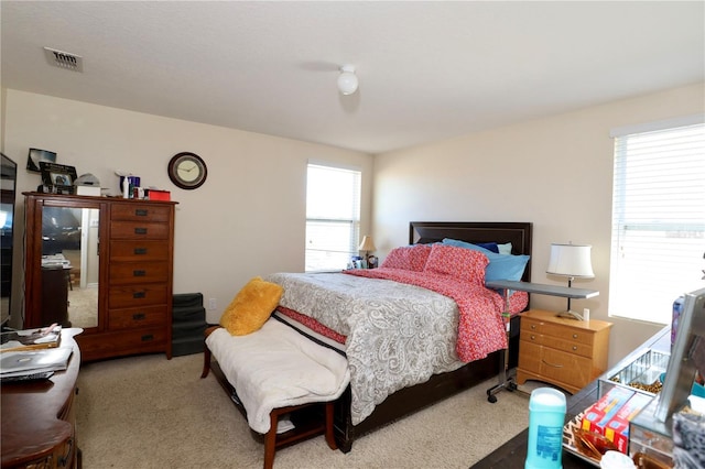 carpeted bedroom featuring visible vents