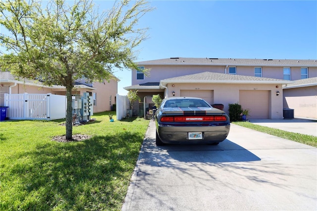 view of front facade featuring fence, stucco siding, concrete driveway, a front lawn, and a garage