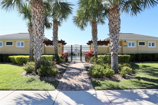 view of property's community featuring a lawn and fence