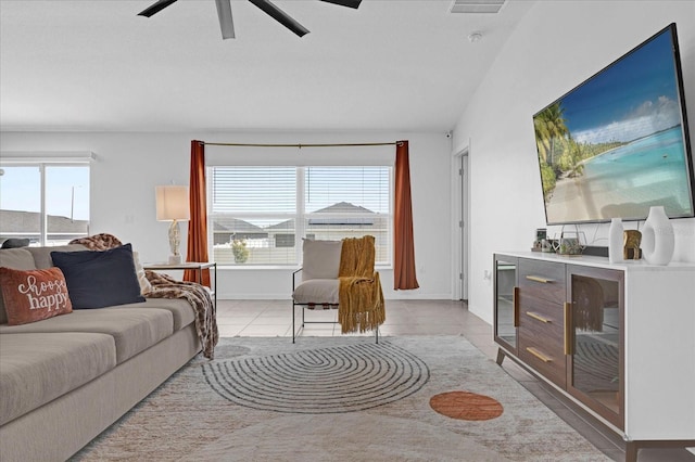 living area featuring baseboards, a ceiling fan, light tile patterned floors, and visible vents