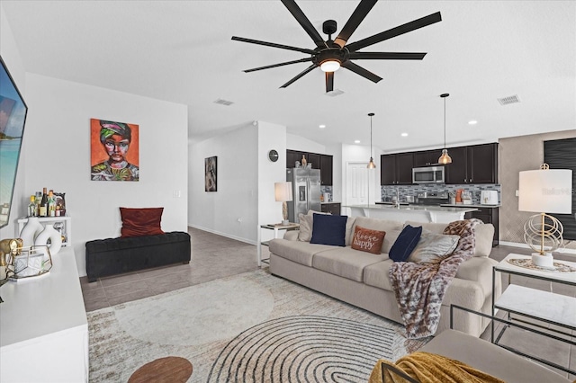 living area featuring baseboards, a ceiling fan, recessed lighting, and visible vents