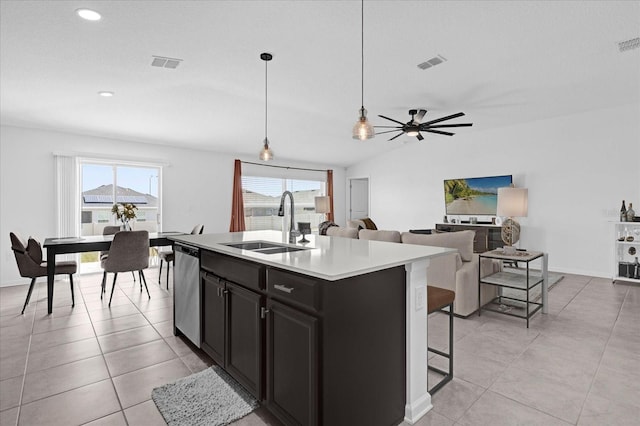 kitchen featuring dark cabinets, dishwasher, a sink, and visible vents