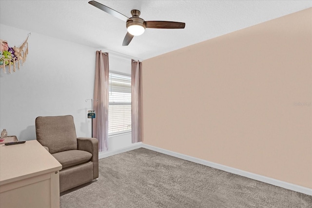 sitting room with baseboards, a ceiling fan, and light colored carpet