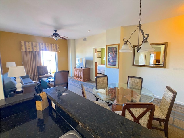 dining space with baseboards, visible vents, and ceiling fan