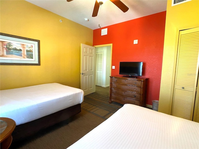 carpeted bedroom featuring lofted ceiling, a ceiling fan, visible vents, and a closet