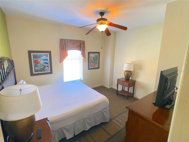 bedroom featuring ceiling fan, baseboards, and dark colored carpet