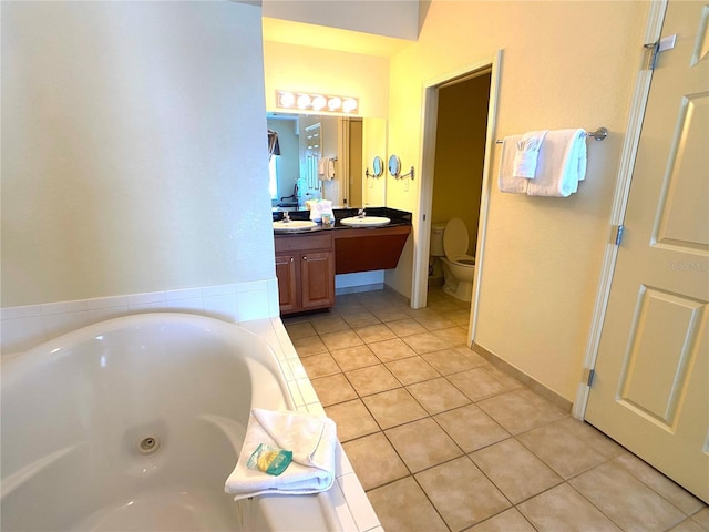 full bath featuring toilet, vanity, a tub with jets, and tile patterned floors