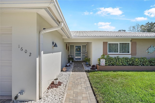 doorway to property featuring a garage and stucco siding