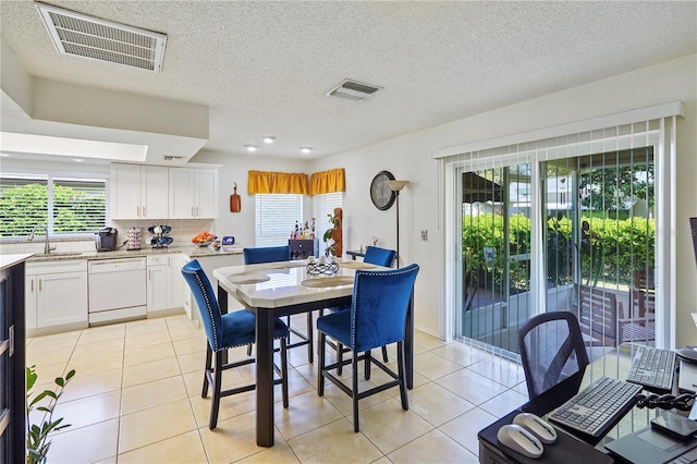 dining room with light tile patterned floors, visible vents, and a healthy amount of sunlight